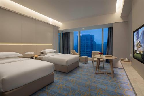a hotel room with two beds and a table at Wyndham Shaoxing Keqiao in Shaoxing