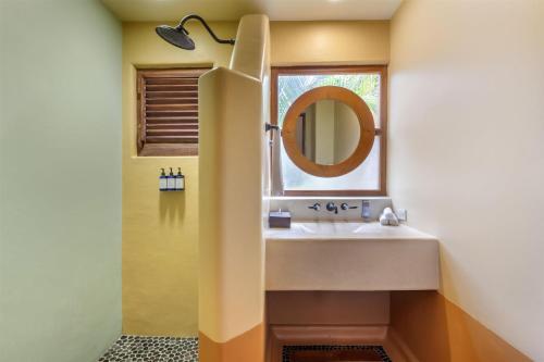 a bathroom with a sink and a mirror at Hilton Grand Vacations Club Zihuatanejo in Zihuatanejo