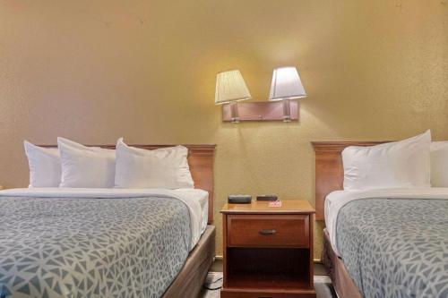 a hotel room with two beds and a night stand at Econo Lodge Raleigh near Walnut Creek Amphitheatre in Raleigh