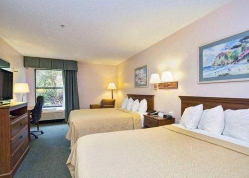 a hotel room with two beds and a desk at Econo Lodge Raleigh near Walnut Creek Amphitheatre in Raleigh