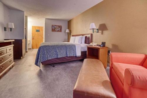 a hotel room with a bed and a couch at Econo Lodge Raleigh near Walnut Creek Amphitheatre in Raleigh