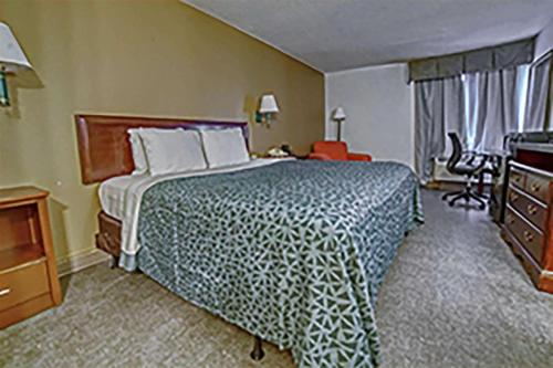 a hotel room with a large bed and a desk at Econo Lodge Raleigh near Walnut Creek Amphitheatre in Raleigh