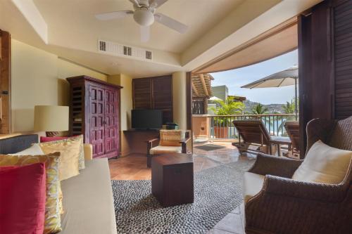 a living room with a couch and chairs and a television at Hilton Grand Vacations Club Zihuatanejo in Zihuatanejo