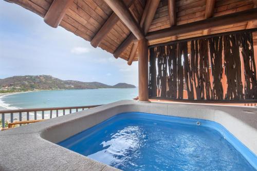 a hot tub on a patio with a view of the ocean at Hilton Grand Vacations Club Zihuatanejo in Zihuatanejo