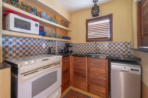 a kitchen with a stove and a microwave at Hilton Grand Vacations Club Zihuatanejo in Zihuatanejo