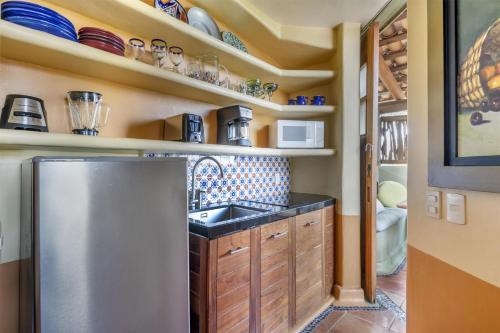 a kitchen with a stainless steel refrigerator and shelves at Hilton Grand Vacations Club Zihuatanejo in Zihuatanejo