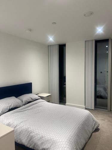 a bedroom with a large bed with white sheets at Luxe Penthouse 2 bed Deansgate in Manchester