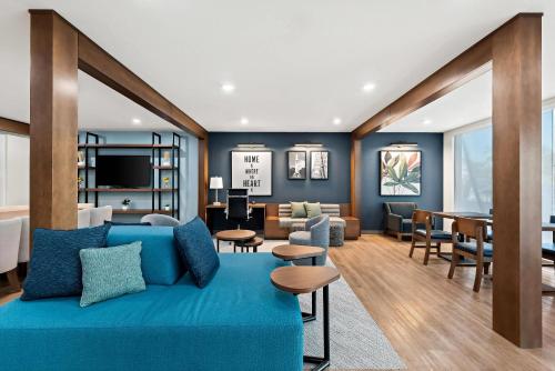 a living room with a blue couch and a dining room at Everhome Suites Huntsville - Research Park in Huntsville
