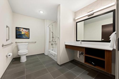a bathroom with a toilet and a sink with a mirror at Everhome Suites Huntsville - Research Park in Huntsville