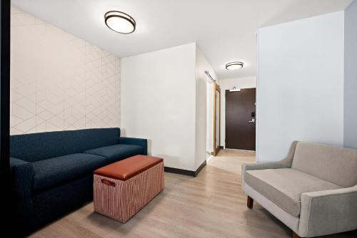 a living room with a blue couch and a chair at Everhome Suites Huntsville - Research Park in Huntsville