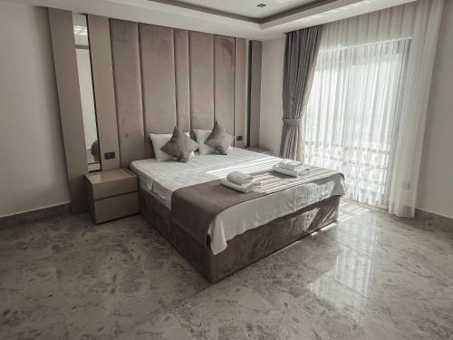 une chambre avec un grand lit et une grande fenêtre dans l'établissement Villa Dolce, à Fethiye