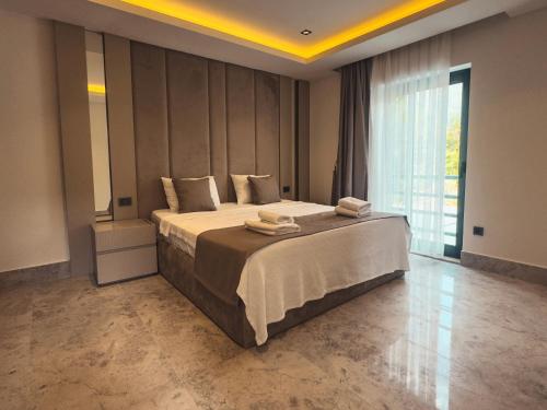 une chambre avec un grand lit et une grande fenêtre dans l'établissement Villa Dolce, à Fethiye