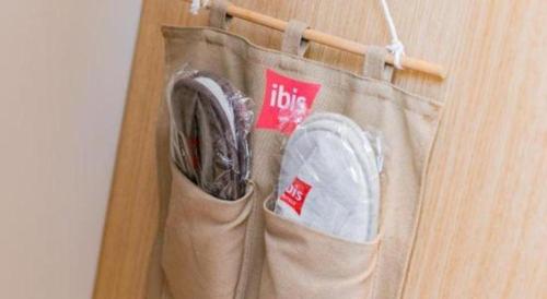 a bag hanging on a wall with aabinet at ibis xian North Second Ring Weiyang Rd Hotel in Xi'an