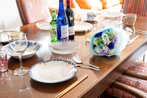 a table with plates and bottles of wine and wine glasses at 大和の宿 Kitakyobate in Nara