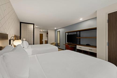 a hotel room with two beds and a flat screen tv at Everhome Suites Temecula in Temecula