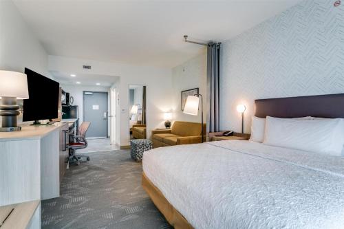 a hotel room with a large bed and a desk at Home2 Suites by Hilton Coppell DFW Grapevine North in Coppell
