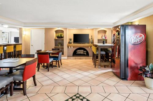 a restaurant with a coke refrigerator and tables and chairs at Econo Lodge Augusta North - Washington Road in Augusta