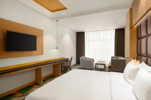 a hotel room with a flat screen tv at Ramada Plaza by Wyndham Jammu Vijaypur in Jammu