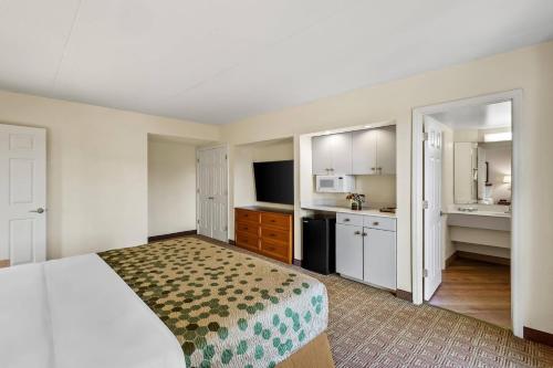 a hotel room with a bed and a kitchen at Econo Lodge Augusta North - Washington Road in Augusta