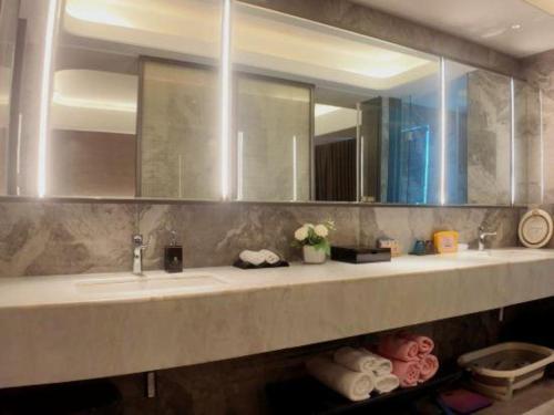 a bathroom with two sinks and a large mirror at Taiyi International Hotel in Wenzhou