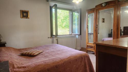 Un dormitorio con una cama con una manta roja y una ventana. en Agriturismo Raggio di Sole, en Montepulciano