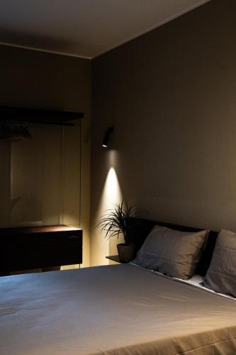 a bedroom with a white bed with a plant at KODERLE SUITE K1 Bucaneve in Brunico