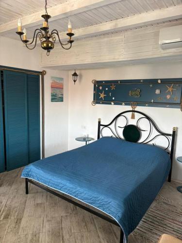 a bedroom with a blue bed and a chandelier at Apartments Marine in Zatoka