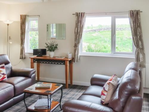 a living room with a couch and a table at Swallow Lodge in Carsphairn