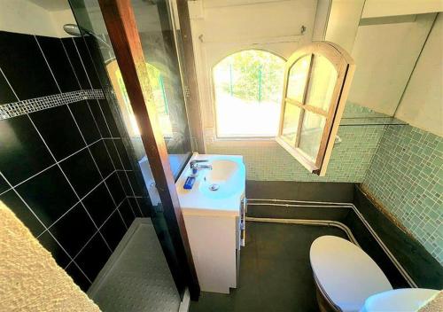 a small bathroom with a sink and a toilet at Charming brickyard cottage near a lock in Ayguesvives