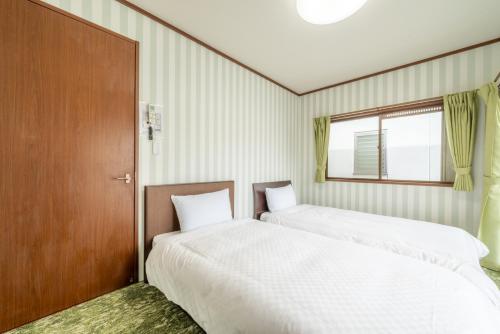 two beds sitting next to each other in a room at 大和の宿 Kitakyobate in Nara