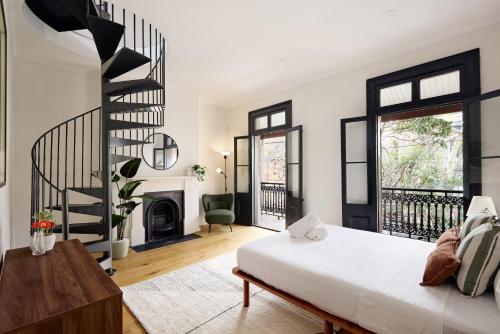 a living room with a bed and a spiral staircase at Spacious Surry Hills Home in Sydney