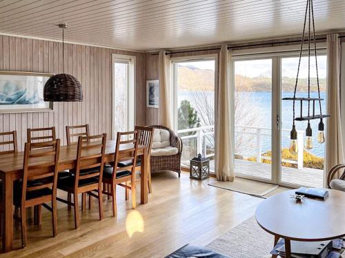 una sala da pranzo con tavolo, sedie e vista di 9 person holiday home in GURSKØY-By Traum a Kjellsund