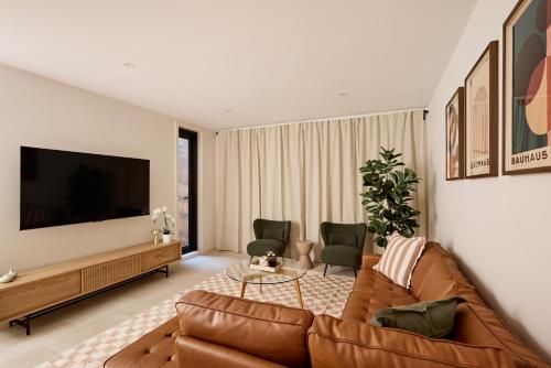 a living room with a couch and a flat screen tv at Spacious Surry Hills Home in Sydney