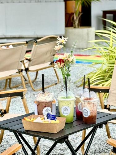 a black table with drinks and snacks on it at The Cozytainer in Taiping