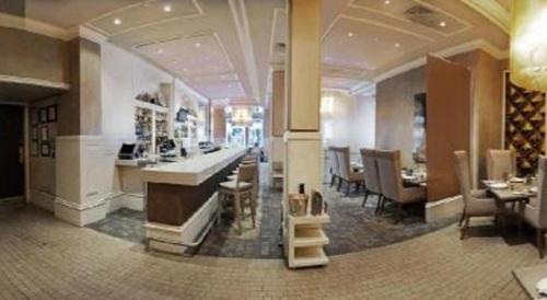 a restaurant with a bar and tables and chairs at Fifteen Beacon Hotel in Boston