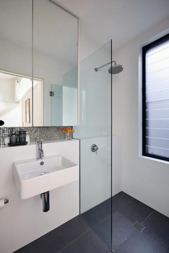 a bathroom with a sink and a glass shower at Spacious Surry Hills Home in Sydney