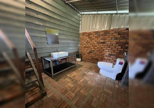 a bathroom with a toilet and a sink at Phum Khnhom Bungalow in Battambang