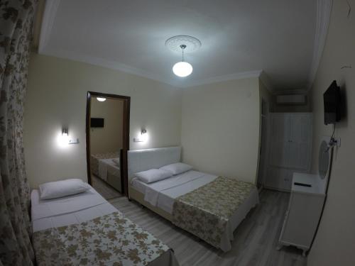a hotel room with two beds and a mirror at Pınar Vintage House in Pamukkale