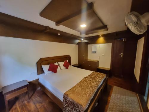 ein Schlafzimmer mit einem großen Bett in einem Zimmer in der Unterkunft Lake Paradise Hoseboat in Alappuzha