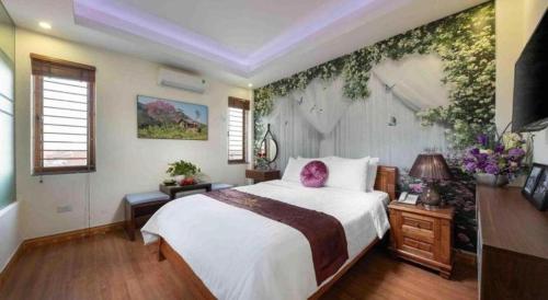 a bedroom with a large bed and a wall with flowers at Viet Village Hotel in Hanoi
