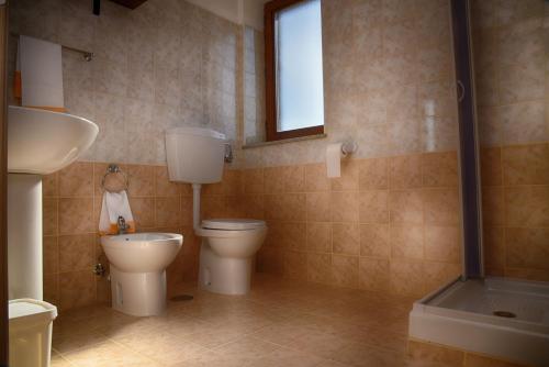 a bathroom with two toilets and a sink and a window at Centro Sportivo Lorica in Lorica