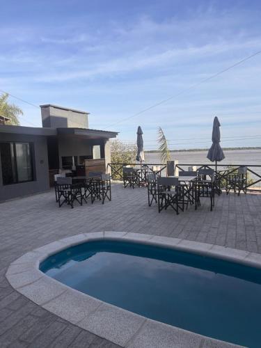 a patio with a swimming pool and tables and chairs at Mathea Apart Hotel in Bella Vista