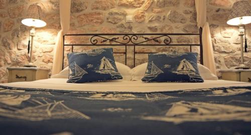 a bed with two blue pillows on top of it at Paradiso in Hydra