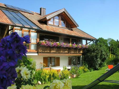 a house with flowers in front of it at Ferienwohnungen Bergblick in Immenstadt im Allgäu