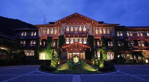 a large building is lit up at night at Unzen Kanko Hotel in Unzen