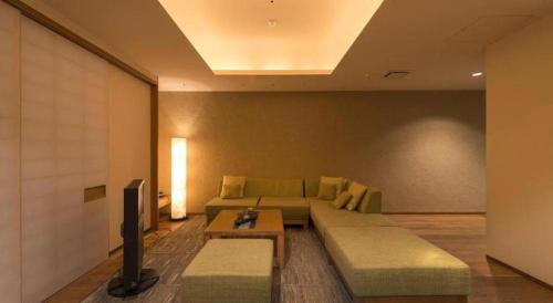 a living room with a couch and a tv at Myoken Ishiharaso in Kirishima