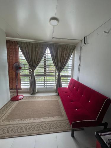 a living room with a red couch and a window at SemiD Double Storey Family Homestay in Sungai Petani