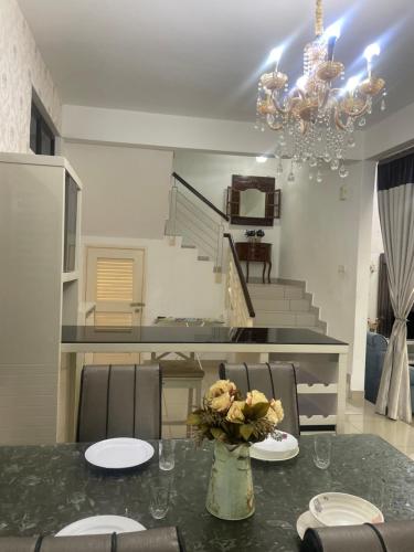 a dining room with a table and a chandelier at SemiD Double Storey Family Homestay in Sungai Petani