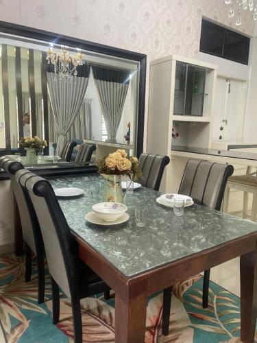 a dining room with a table with chairs and a kitchen at SemiD Double Storey Family Homestay in Sungai Petani