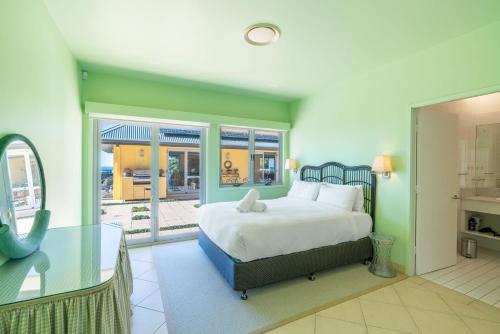 Un dormitorio con una cama y una mesa de cristal. en Flametrees, en Jamberoo